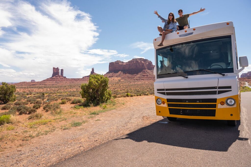 Couple enjoying a summer RV road trip in Monument Valley, Utah.